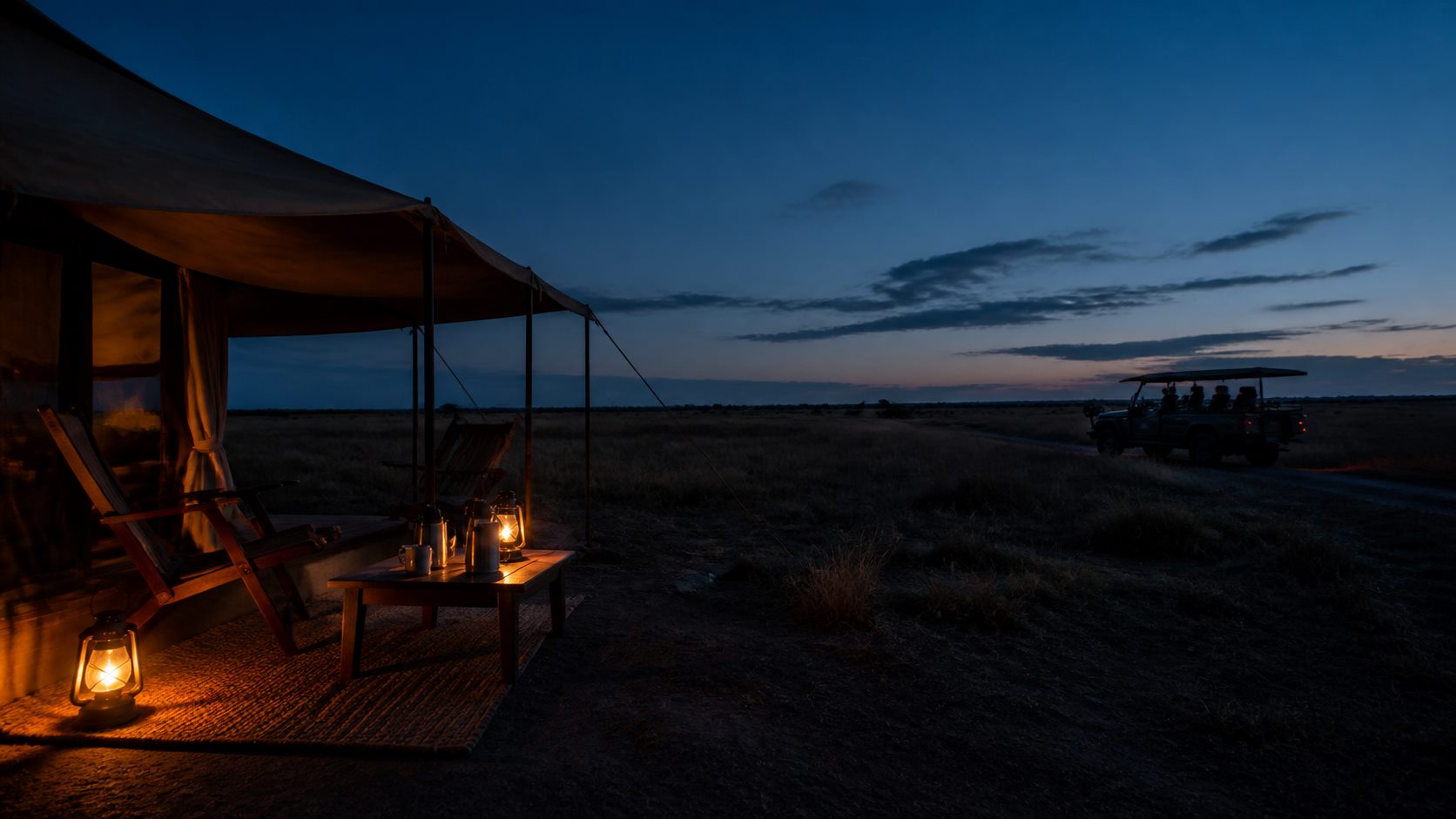 Lantern-lit canvas and a safari vehicle before dawn on the plains